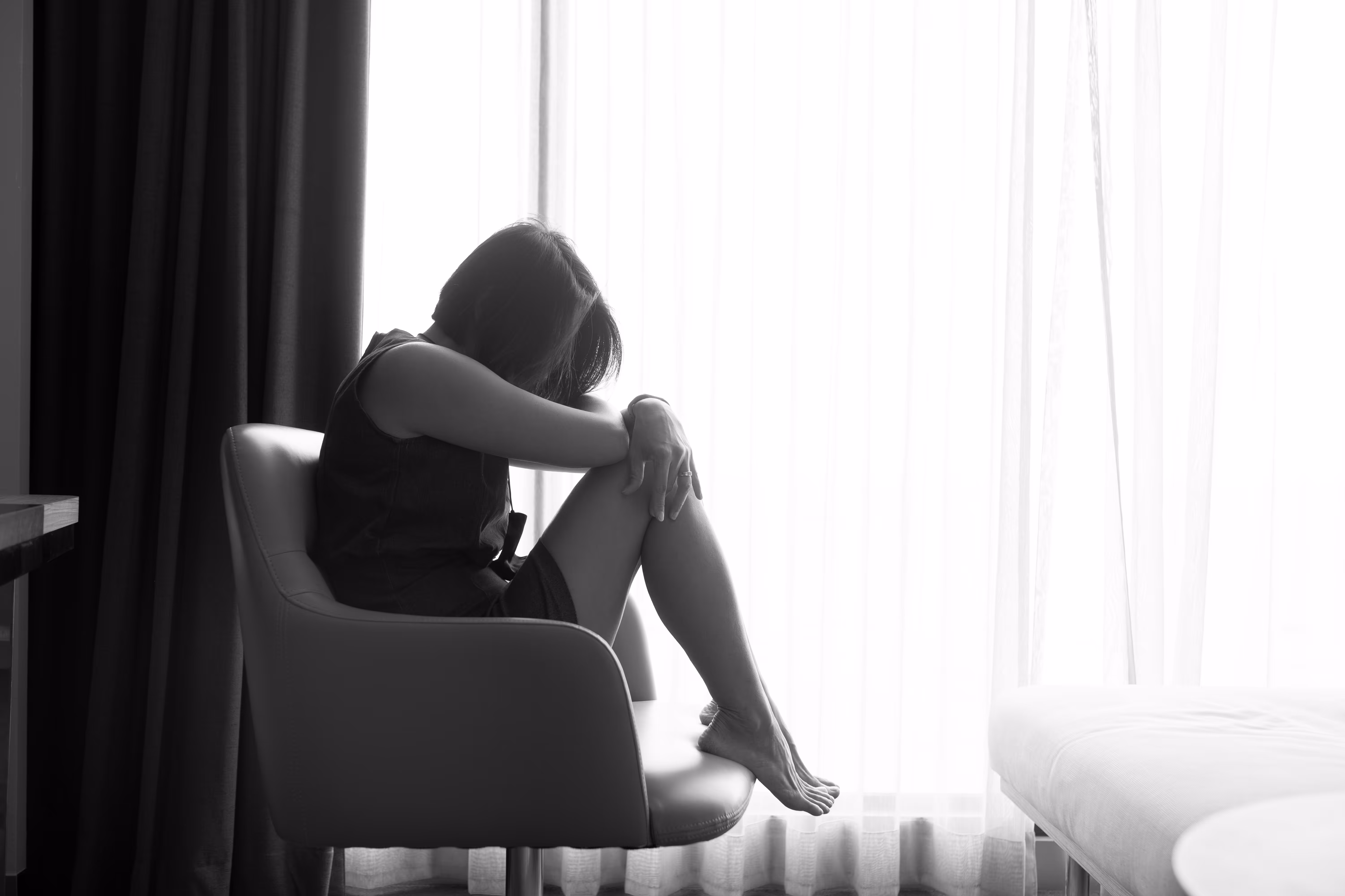 窓辺で落ち込む女性